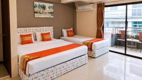 two beds in a room with a balcony at Fortune Pattaya Resort in Jomtien Beach