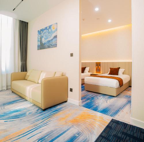 a hotel room with two beds and a couch at Zenn Hotel Erdenet in Erdenet