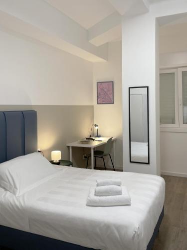 a bedroom with a white bed and a desk at Guest House Biscardi in Bari
