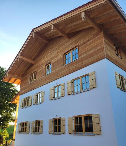 a house with a wooden roof and windows at Ferienhof Winkler in Bernbeuren