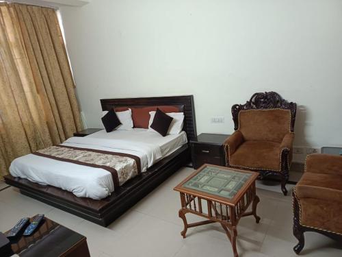 a bedroom with a bed and a chair and a table at Hotel Home Stay Dwarka in New Delhi
