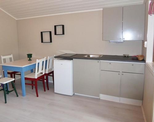 a kitchen with a table and a blue table and chairs at Sona Camping in Hegra