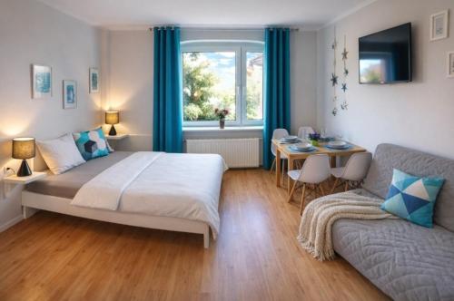 a bedroom with a bed and a table and a couch at Kotwica Puck in Puck