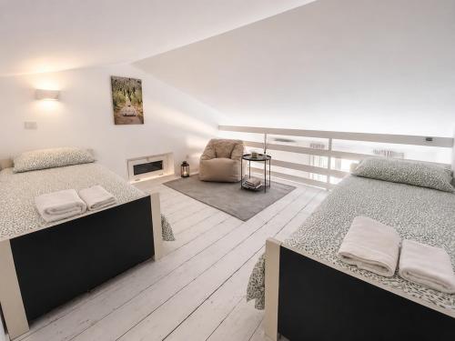 a bedroom with two beds and a chair at Casa PG - Appartamento Vista Lago in Monte Isola