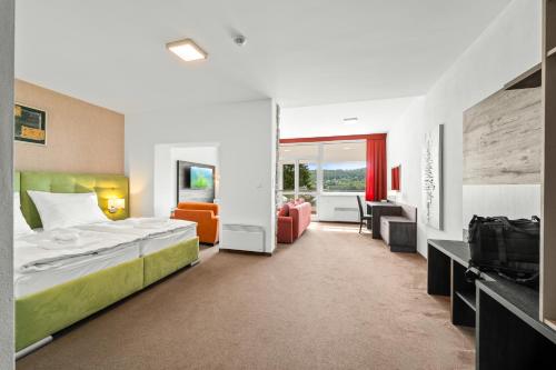 a hotel room with a bed and a living room at Apartmány Star Lipno - Self Check-in in Lipno nad Vltavou