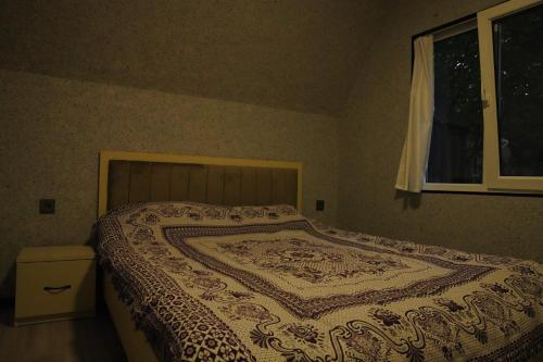 a bedroom with a bed with a patterned blanket on it at Family House Quba, Guba, Qeçreş,Qəçrəş,Qecresh in Qǝçrǝş