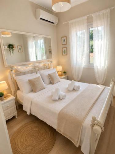 a bedroom with a large white bed with two towels on it at Kayani View in Taxiárkhai