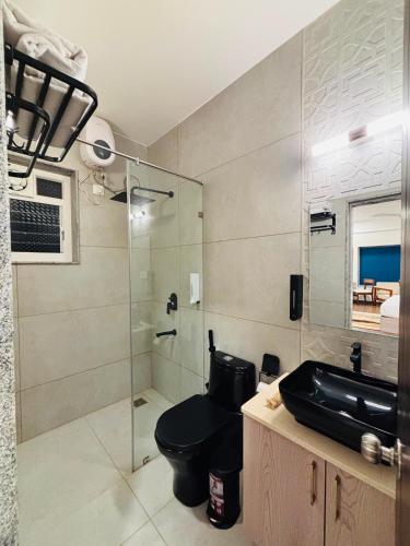 a bathroom with a toilet and a glass shower at Nivaara by GHD Hotels in Nerul