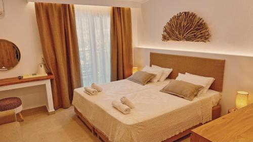 a bedroom with a bed with two towels on it at Hotel Zafira in Skala Rachoniou