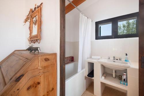 a bathroom with a sink and a toilet and a mirror at Can Carabá in Illes Balears