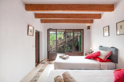 two beds in a room with white walls and wooden beams at Can Carabá in Illes Balears