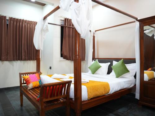 a bedroom with a canopy bed and a chair at The Tree Resort in Malavli