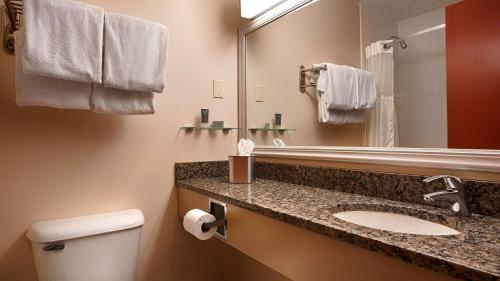 a bathroom with a sink and a mirror and a toilet at Silver Fox Inn in Waterville Valley