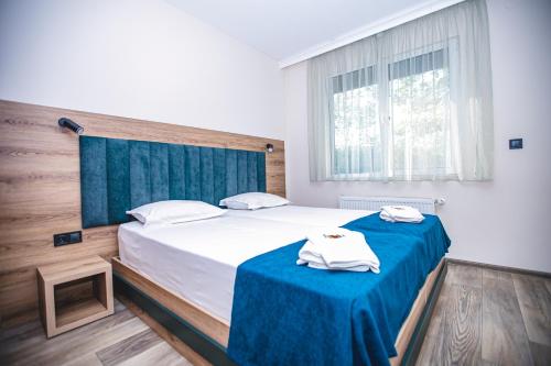 a bedroom with a bed with two towels on it at Complex Perpera in Stambolovo