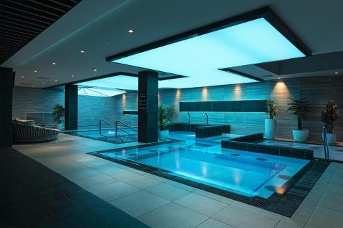 a large swimming pool in a building with a lit up room at Avalon Resort & SPA in Miskolctapolca