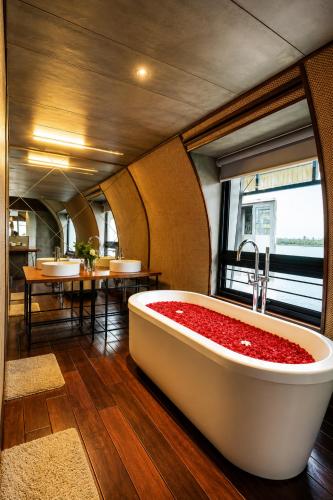 a bath tub filled with red flowers in a room at Southern Panorama Houseboats in Alleppey