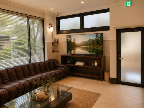a living room with a couch and a tv at 別荘 1日1組貸切 芦ノ湖徒歩1分 最大16名 BBQ設備レンタルOk 無料駐車場 in Hakone