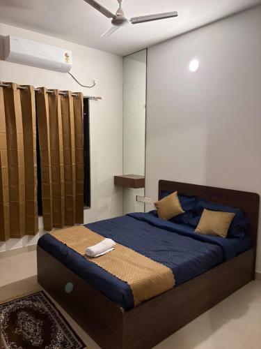a bedroom with a bed with blue sheets and a ceiling at coastal coral in Tirupporūr