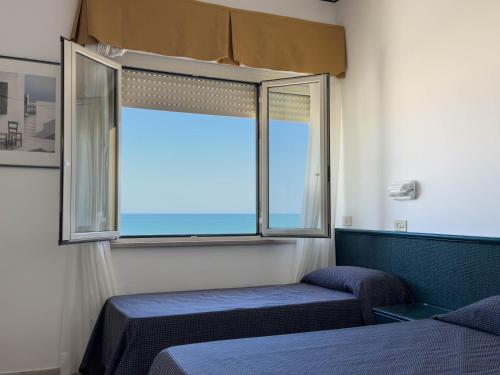 a bedroom with two beds and a window at Hotel Excelsior in Fano