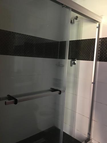 a bathroom with a shower with a glass door at HOTEL GANI in Manjacaze