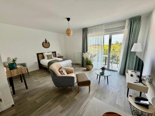 a bedroom with a bed and a living room at DOMITYS - Les Cerfs-Volants in Berck-sur-Mer