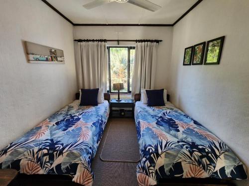 a bedroom with two beds and a window at Peter Pan Place in Port Edward