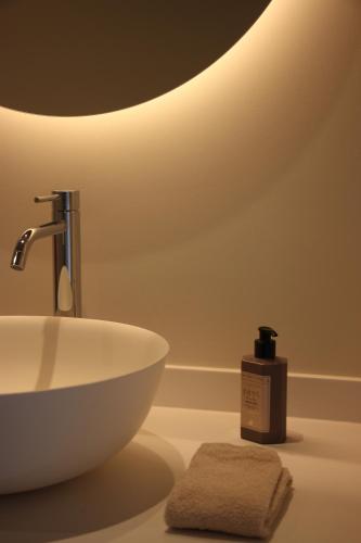 a bathroom with a sink and a bottle of soap at Het Plategoed in Oosthoek