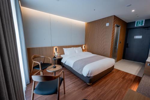 a hotel room with a bed and a table and chairs at Jamsil Hotel Vene in Seoul