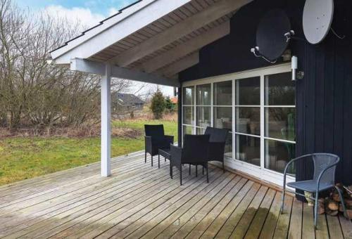 a patio with a table and chairs on a deck at Coastal Hideout Vacation Home in Bøtø By