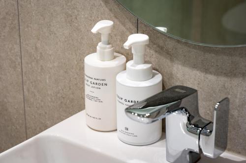 two bottles ofodorizers are sitting on a bathroom sink at Jamsil Hotel Vene in Seoul