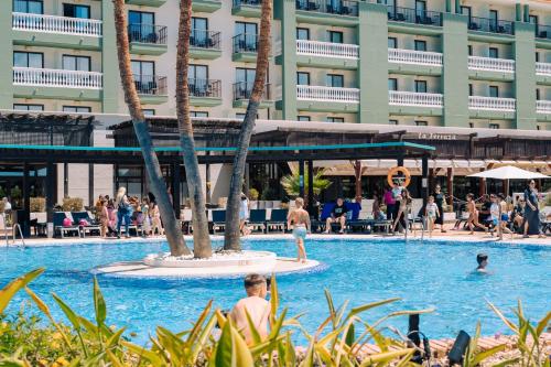 a pool at a hotel with people in the water at Smy Isla Cristina in Isla Cristina