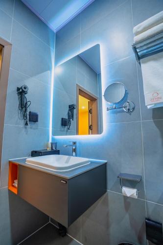 a bathroom with a sink and a mirror at Zenn Hotel Erdenet in Erdenet
