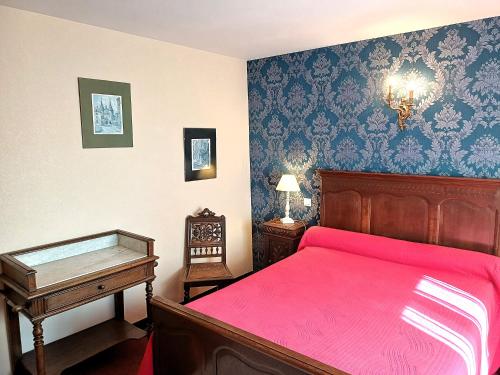 a bedroom with a bed with a red bedspread at Le Commerce in Bulgnéville