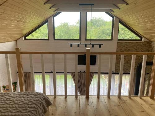 a bedroom with a bed in a room with windows at Rose & Raspberry Garden in Shevchenkovo