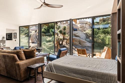 a bedroom with a large wall of windows at Mod West Ranch: 5-acre Boulder Playground in Pioneertown