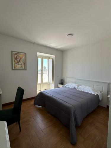 a bedroom with a large bed and a chair at Kento Resort Hotel in Centuripe