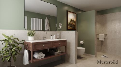 a bathroom with a sink and a toilet and a mirror at Hotel-Restaurant Anne-Sophie in Künzelsau