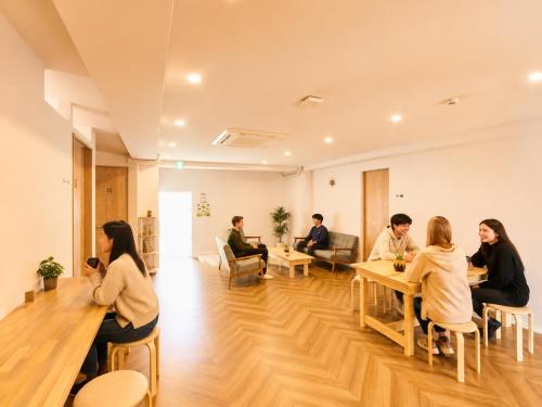 a group of people sitting at tables in a room at Southern Gate HIVE in Ishigaki Island