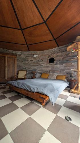 a bedroom with a bed with a wooden ceiling at La Rond'Dada in Sainte-Suzanne