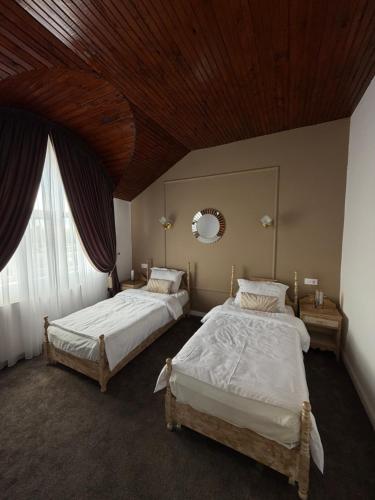 two beds in a bedroom with a wooden ceiling at Hotel Turist Beharca in Beharca