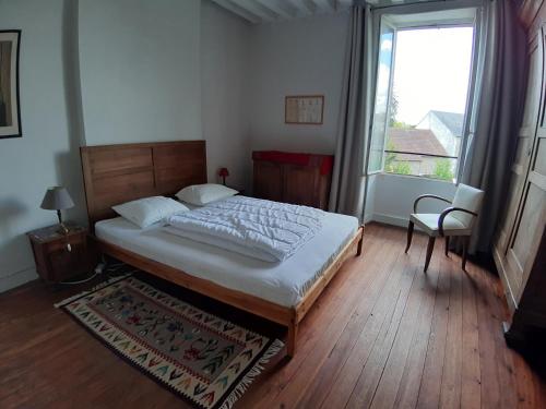 a bedroom with a bed and a large window at Maison Corbigny in Corbigny