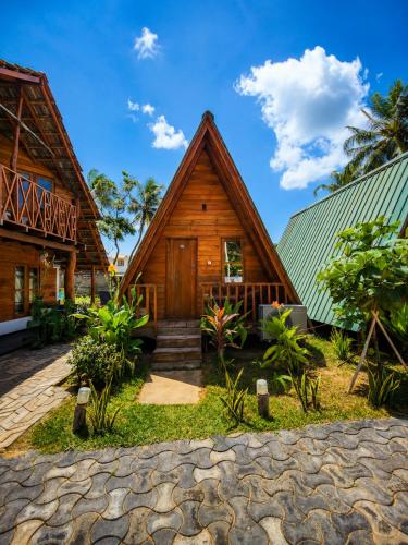a wooden house with a green roof at Nilaveli Sheen Coast in Trincomalee