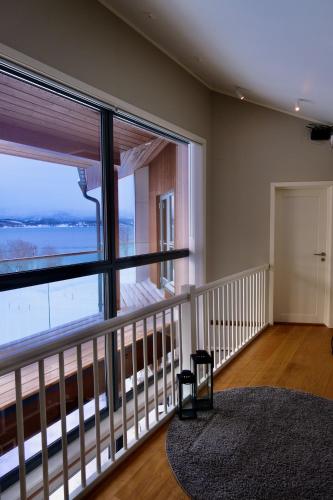 a room with a balcony with a large window at Modern house secluded in nature in Storbukt