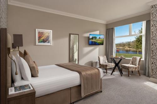 a hotel room with a bed and a table with chairs at Killyhevlin Lakeside Hotel & Lodges in Enniskillen