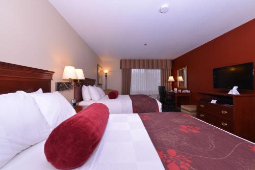 a hotel room with two beds and a flat screen tv at Best Western Plus Rama Inn in Redmond
