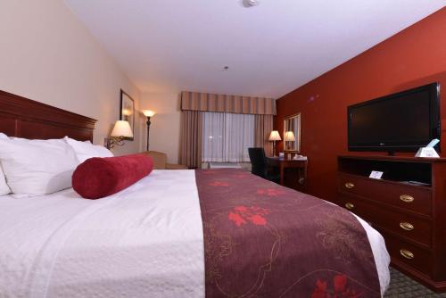 a hotel room with a bed and a flat screen tv at Best Western Plus Rama Inn in Redmond