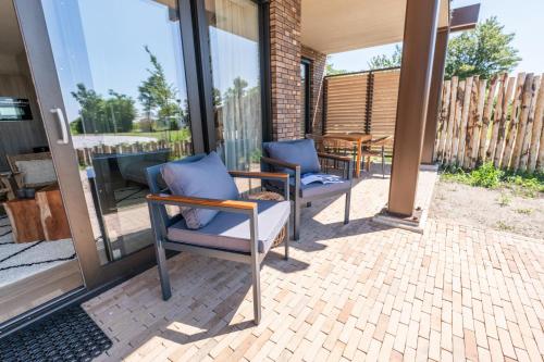 a patio with two chairs and a table at MarinaPark Beach Resort Soal - Wellness Apartments in Workum