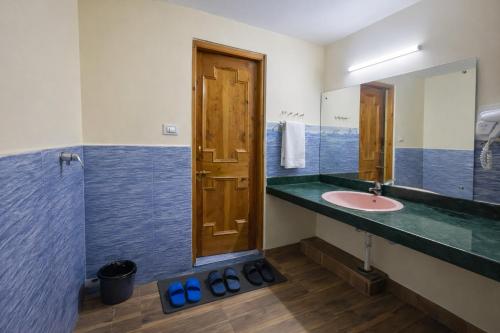 a bathroom with a sink and a mirror at Woods Villa Cottages Manali - 1,2,3,4 Bedrooms Luxury Cottages & Villa Available in Manali with Scenic Mountain View, Manali in Manāli