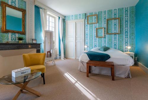 a bedroom with a bed and a table and a chair at Logis Hotel Le Prince Noir in Sérignac-sur-Garonne