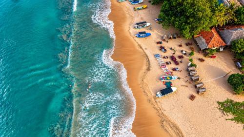 an aerial view of a beach with umbrellas and people at Nilaveli Sheen Coast in Trincomalee